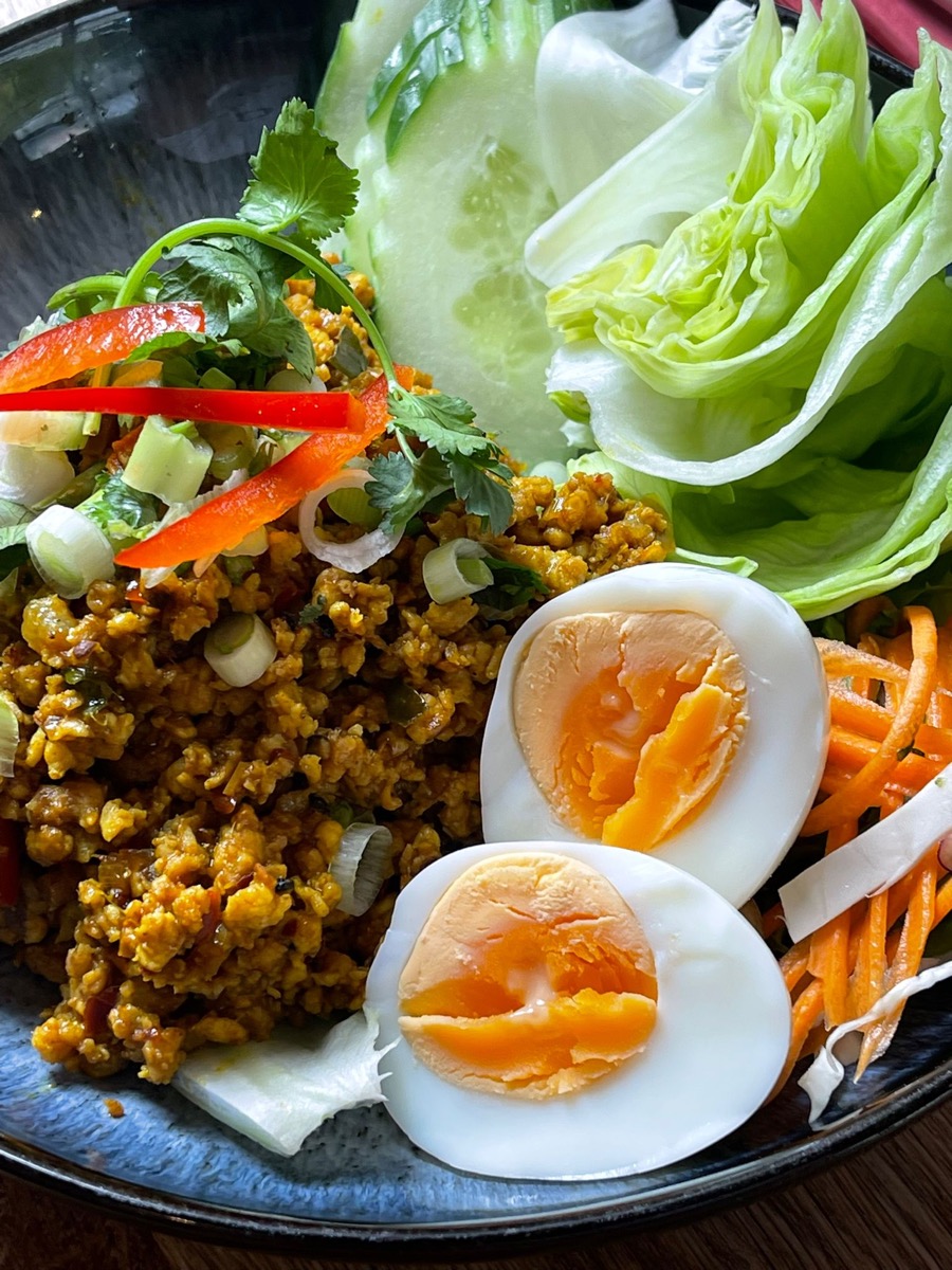 A Thai dish at Olive & Thai, served with soft-boiled eggs, fresh herbs and lettuce.